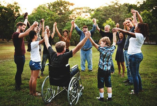 Group of people in a circle holding hands high in the air.