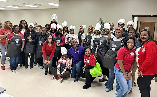 Group of people pose in their aprons.