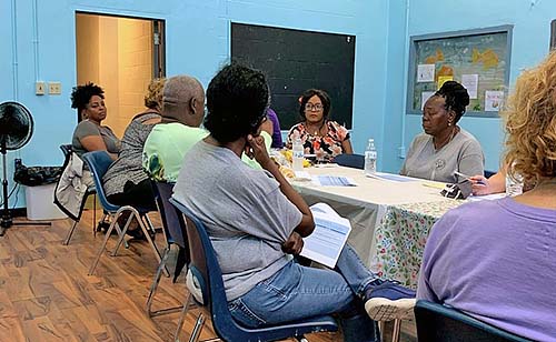 Ladies sitting at a table having a discussion.