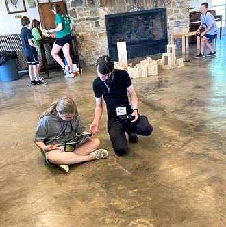 Teen leader works with student.