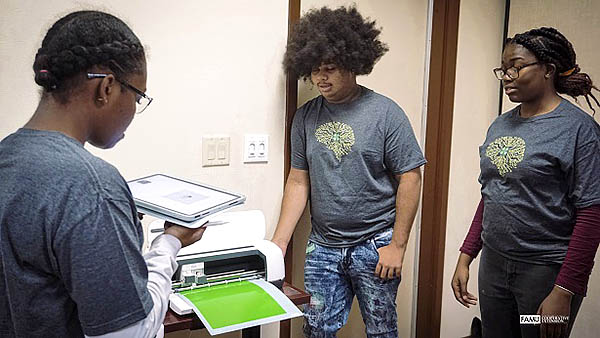 4-H Tech Changemakers use a 3-D printer.