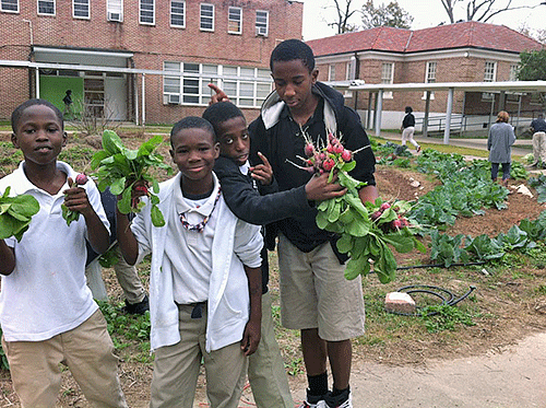 Photo courtesy of Stephanie Elwood. Thrive Academy students display the radishes they grew and picked from their campus garden as a part of the SU Ag Center’s Fast Track Program.