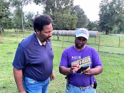 Extension agent speaks to farmer Byron Haskins.