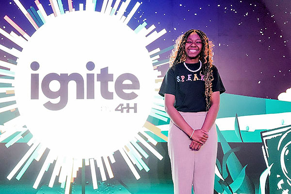 4-H’er Zy’Keria Aaron with Ignite by 4-H backdrop.