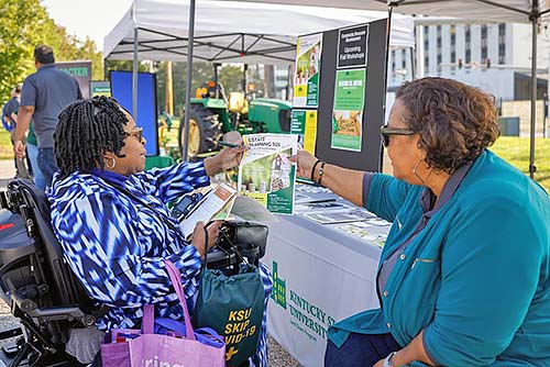 Irma Johnson hands out flyers for Estate Planning 101 at KSU Day at the Franklin County Farmers Market.