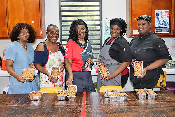 Carol Shoy poses with students and community members after a cooking class.