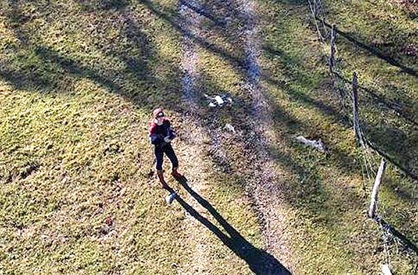 A West Virginia State University Extension educator is seen flying a drone over farmland.