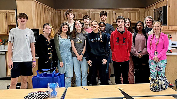 Students stand together as a group.