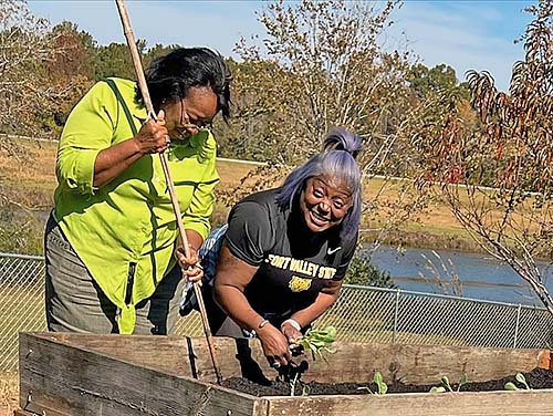 Terralon Chaney works in raised bed with client.
