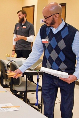 EFNEP nutrition educators Joshua Davis and Joshua Todd, present a smart shopping exercise to eighth graders from Millwood Middle School.