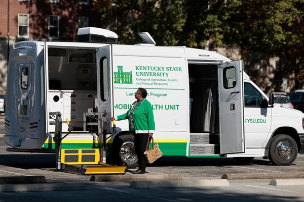 Woman walks toward mobile health unit.