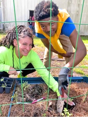 Students work in garden bed.