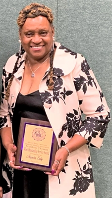 Manola Erby holds her award.