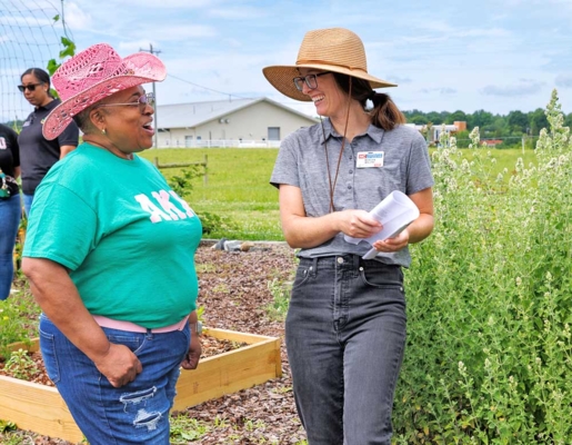 Rhonda Watlington chats with Extension Associate Morgan Malone at the community garden.