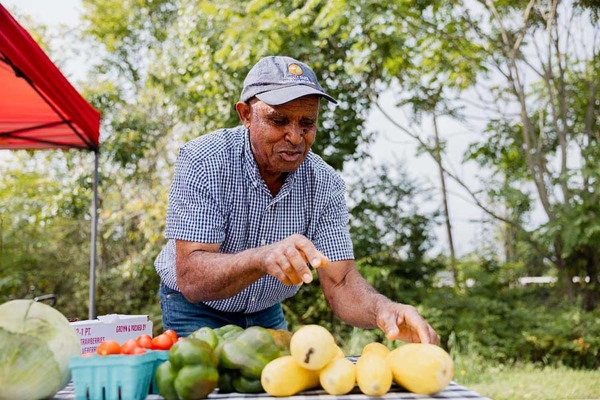 Volunteer assisting with setting up a community farmers market at Eden’s Garden.