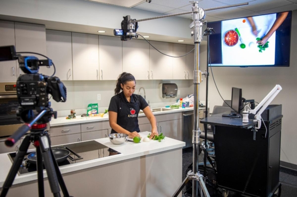Kateira Hogan prepares a meal during a video shoot for her virtual cooking demonstration.