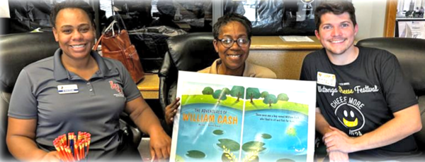 Dr. Tiffany Williams, Keisha Scott and Jadon West holding pages from a book.