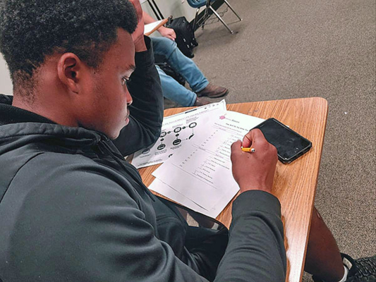Student completes budgeting worksheet.