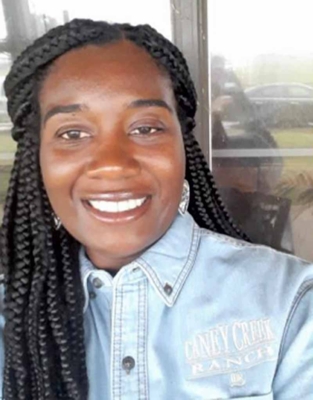 Headshot of Kimberly Ratcliff smiling in front of a window.