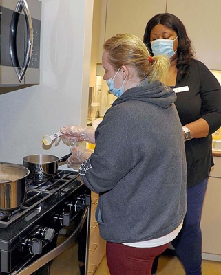 Courtney Williams, UAPB EFNEP Extension aide, teaches adult program participant how to prepare a healthy, nutritious meal.