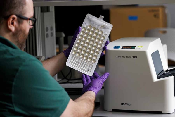 Man with gloves testing water quality.