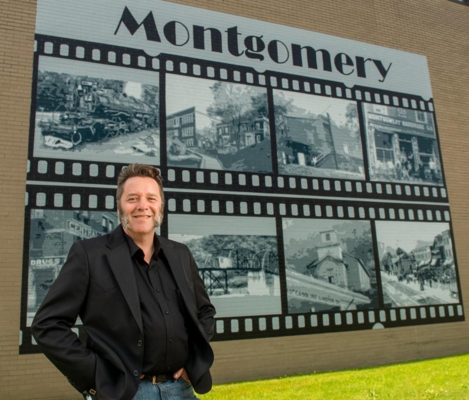 Adam Hodges stands in front of the finished mural.