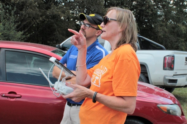 Dr. Jason de Koff helps a farmer test drive a drone.