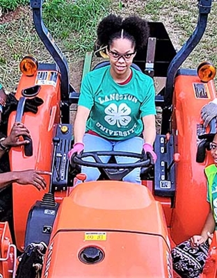 Makayla Gilbert operates a tractor.