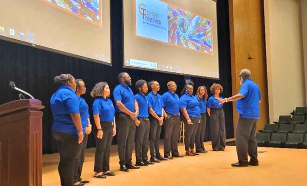 Extension group standing on stage as they participate in the Coming Together training.