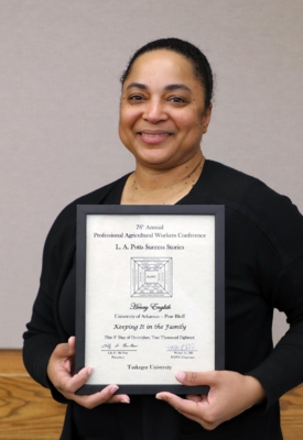 Kandi Williams, Extension program aide and outreach coordinator for the “Keeping it in the Family” (KIITF) Program, holds the L.A. Potts Success Stories award.