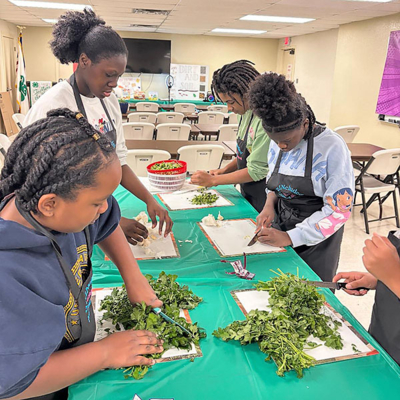 Students prepare food on a table.
