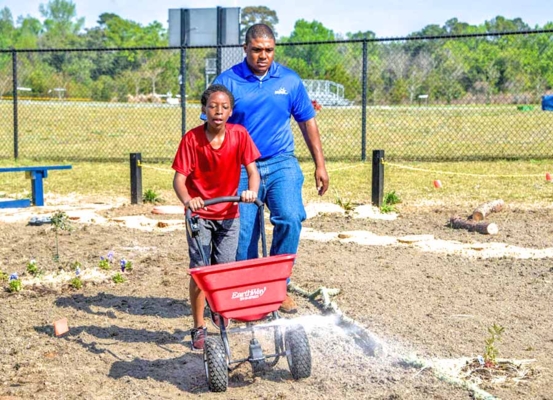 Joshua Dawson monitors student working in garden.