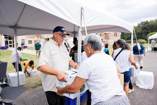 SFOP's director, William Crutchfield, giving away boxes of fresh produce at event.