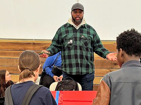 Youth Program Educator Dean O. Purnell speaks to a group of students.