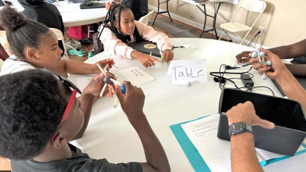 Students work at table.