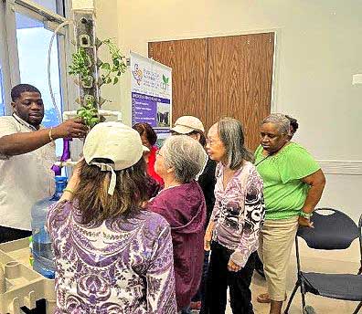 Specialist demonstrates how to use hydroponics system.