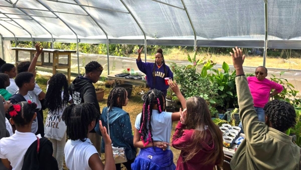 Educator with students in hoop house.